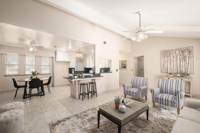 tiled living room with lofted ceiling, a textured ceiling, and ceiling fan