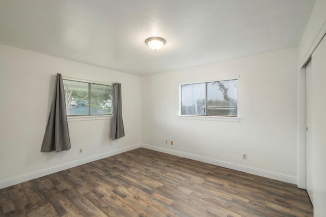 unfurnished bedroom featuring a closet and dark hardwood / wood-style floors