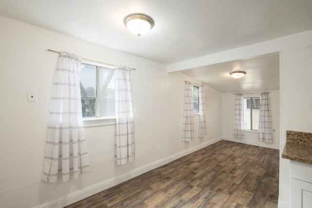 spare room with dark hardwood / wood-style floors and a healthy amount of sunlight