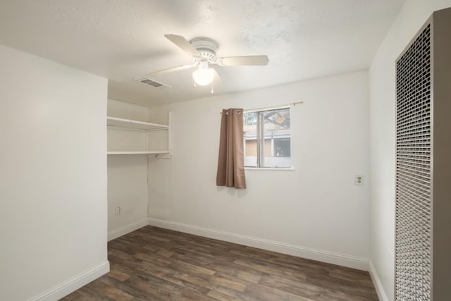 walk in closet with ceiling fan and dark hardwood / wood-style flooring