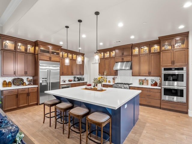 kitchen featuring decorative backsplash, pendant lighting, a center island, and stainless steel appliances