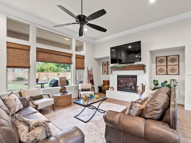 living room featuring light wood-type flooring, ceiling fan, and ornamental molding