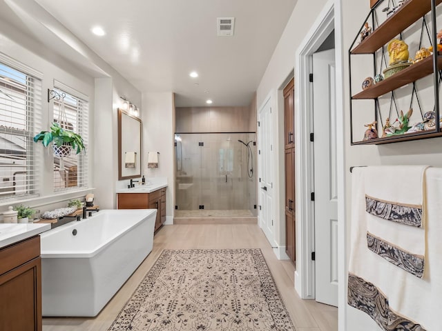 bathroom featuring vanity and shower with separate bathtub