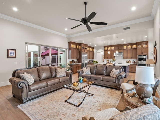 living room featuring hardwood / wood-style floors, ceiling fan, and ornamental molding