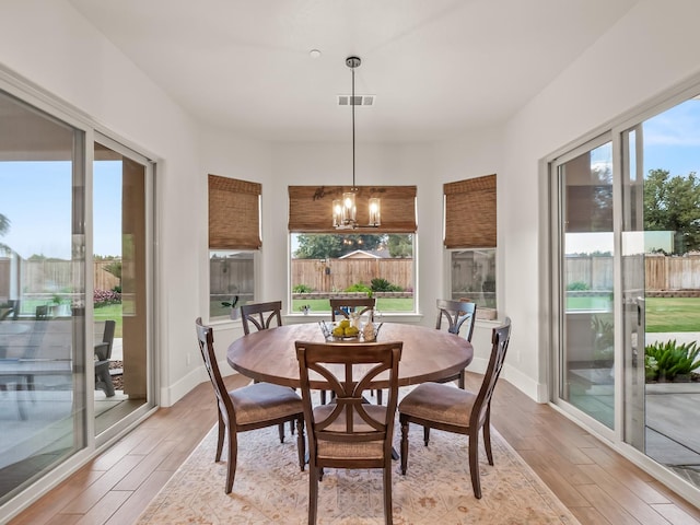 dining area featuring light hardwood / wood-style flooring, a chandelier, and plenty of natural light