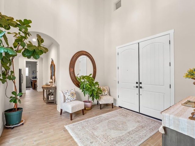 foyer entrance with a high ceiling and light wood-type flooring