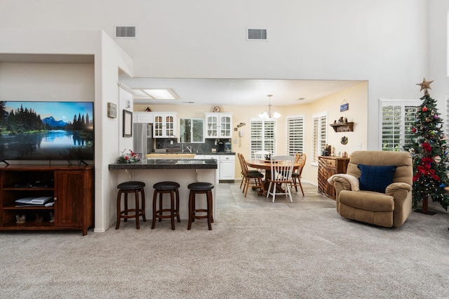 kitchen with plenty of natural light, a breakfast bar, stainless steel fridge, and white cabinets