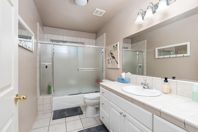 full bathroom featuring vanity, toilet, tile patterned floors, and shower / bath combination with glass door