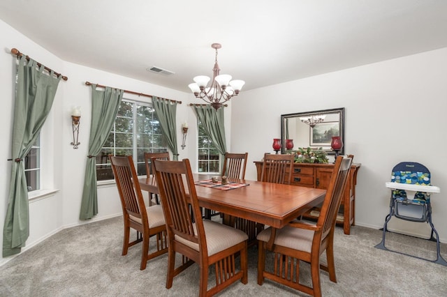 carpeted dining room featuring a notable chandelier