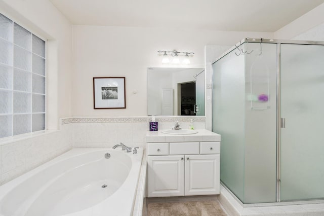 bathroom with vanity and shower with separate bathtub