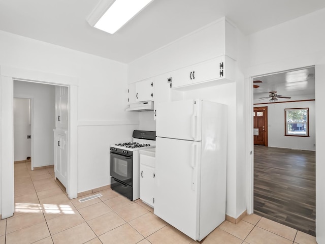 kitchen featuring black gas stove, white cabinets, light wood-type flooring, and white refrigerator