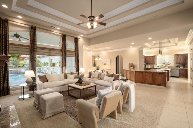 tiled living room featuring crown molding, a tray ceiling, and ceiling fan