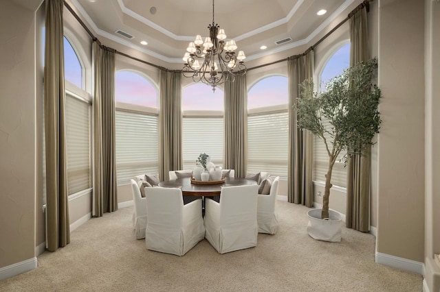 dining room with crown molding, light colored carpet, a notable chandelier, and a raised ceiling