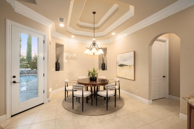 dining area with a tray ceiling, a notable chandelier, ornamental molding, and light tile patterned floors