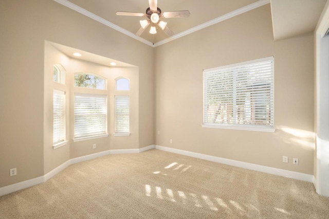 spare room featuring crown molding, carpet floors, a healthy amount of sunlight, and ceiling fan