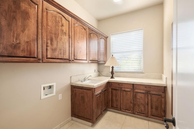 clothes washing area with cabinets, hookup for a washing machine, light tile patterned flooring, and sink