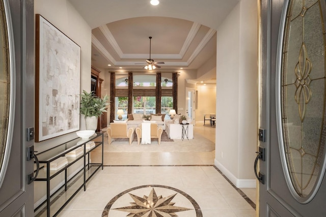 interior space featuring ceiling fan, a raised ceiling, and crown molding