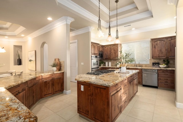 kitchen with backsplash, appliances with stainless steel finishes, a tray ceiling, crown molding, and a center island