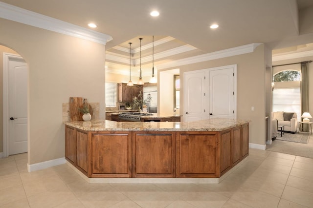 kitchen featuring kitchen peninsula, light stone counters, decorative light fixtures, crown molding, and light tile patterned floors