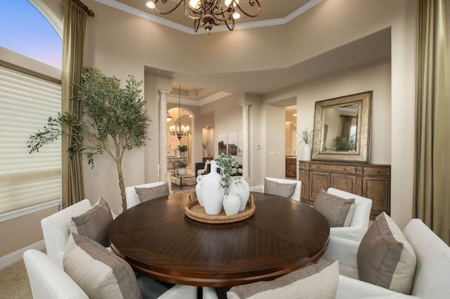 dining space featuring crown molding, a notable chandelier, and decorative columns