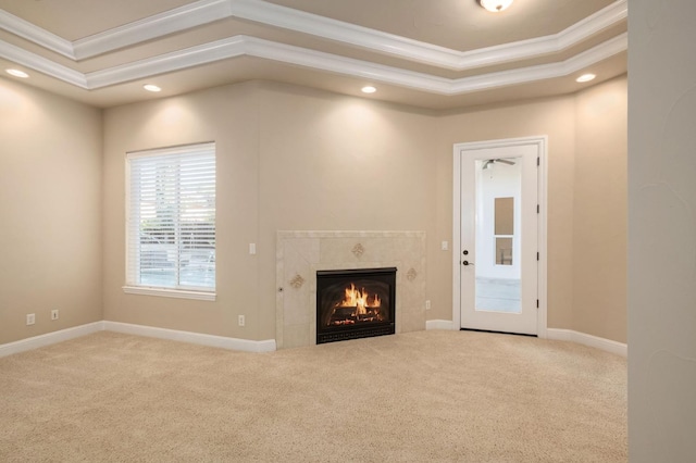 unfurnished living room featuring ornamental molding, a raised ceiling, and carpet floors