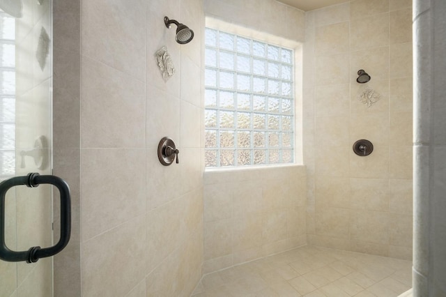 bathroom with a shower with door and plenty of natural light