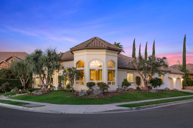 mediterranean / spanish home featuring a lawn