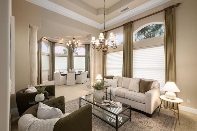 carpeted living room featuring ornamental molding, ornate columns, an inviting chandelier, and plenty of natural light