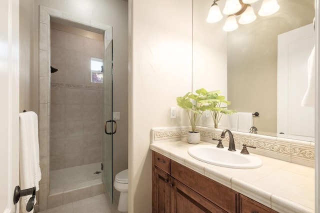 bathroom with vanity, toilet, tile patterned floors, and a shower with door