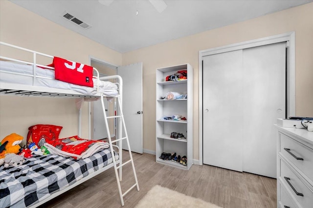 bedroom featuring ceiling fan, a closet, and light hardwood / wood-style flooring