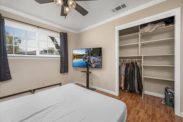 bedroom with hardwood / wood-style floors, crown molding, a closet, and ceiling fan