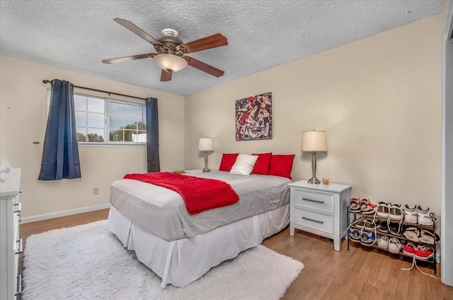 bedroom featuring a textured ceiling, light hardwood / wood-style flooring, and ceiling fan