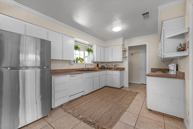 kitchen with light tile patterned flooring, sink, crown molding, white appliances, and white cabinets