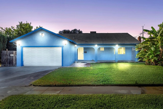 ranch-style house with a yard and a garage