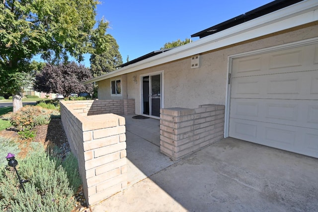 exterior space with brick siding, a patio, and stucco siding