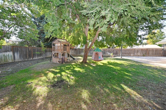 view of yard featuring a playground and a fenced backyard