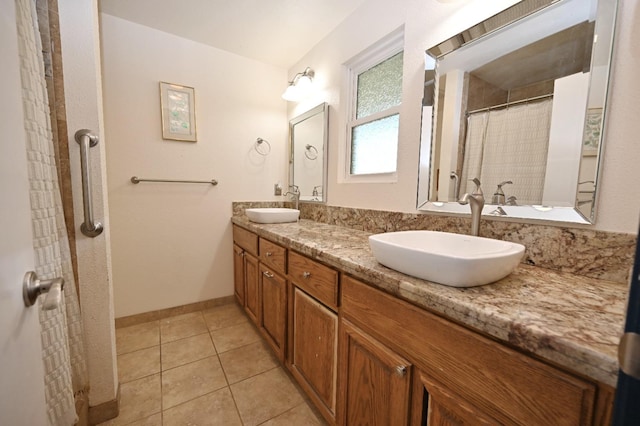 bathroom featuring double vanity, tile patterned flooring, baseboards, and a sink