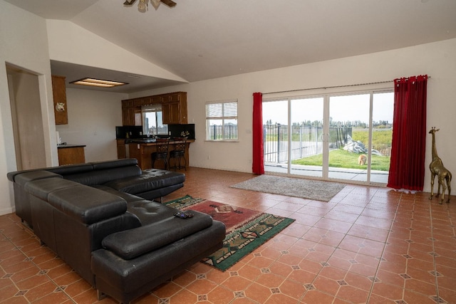 living room featuring lofted ceiling, sink, and tile patterned floors