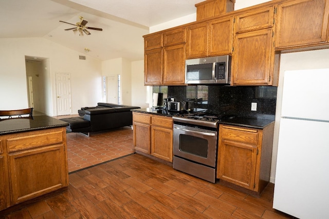 kitchen featuring dark wood-type flooring, ceiling fan, appliances with stainless steel finishes, and decorative backsplash