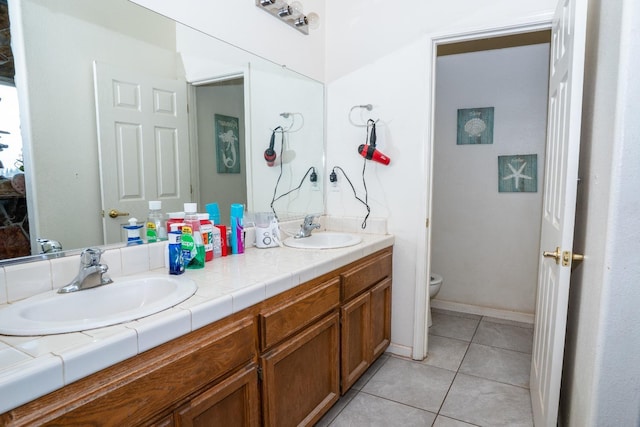 bathroom featuring vanity, tile patterned floors, and toilet