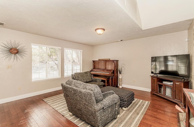 living room with a textured ceiling and hardwood / wood-style floors