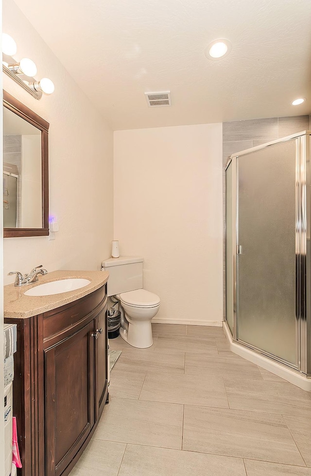 bathroom with vanity, toilet, and walk in shower