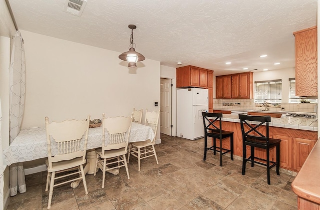 dining area featuring a textured ceiling and sink