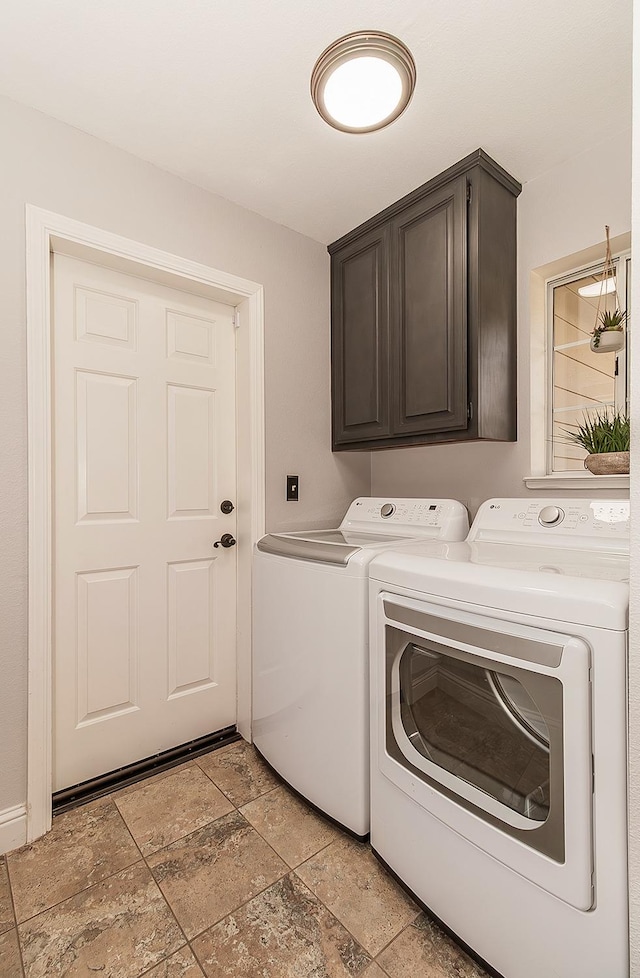 laundry room with independent washer and dryer and cabinets