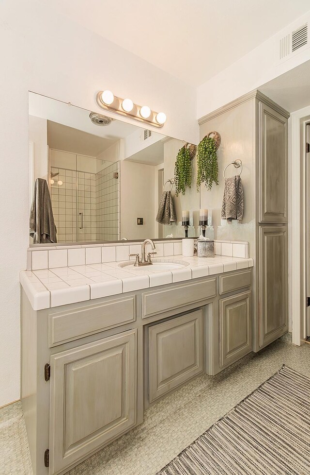 bathroom with vanity and a shower with shower door