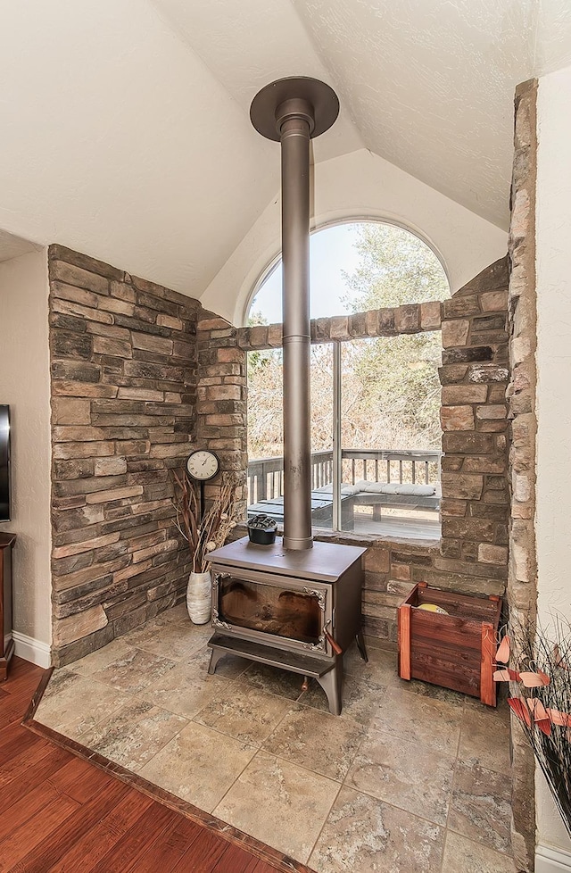 interior space with a wood stove and wood-type flooring