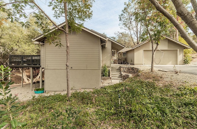 view of property exterior with a wooden deck and a garage