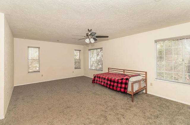 carpeted bedroom with ceiling fan and a textured ceiling