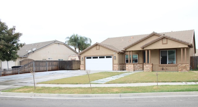 view of front of home featuring driveway, stone siding, fence, and stucco siding