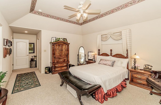 bedroom featuring lofted ceiling, a raised ceiling, light carpet, and ceiling fan